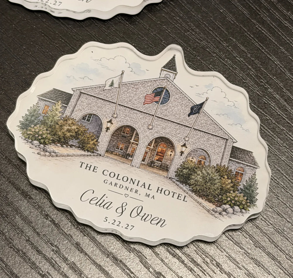 A scalloped acrylic wedding magnet showing a pale venue building with arched entrances and personalized lettering.