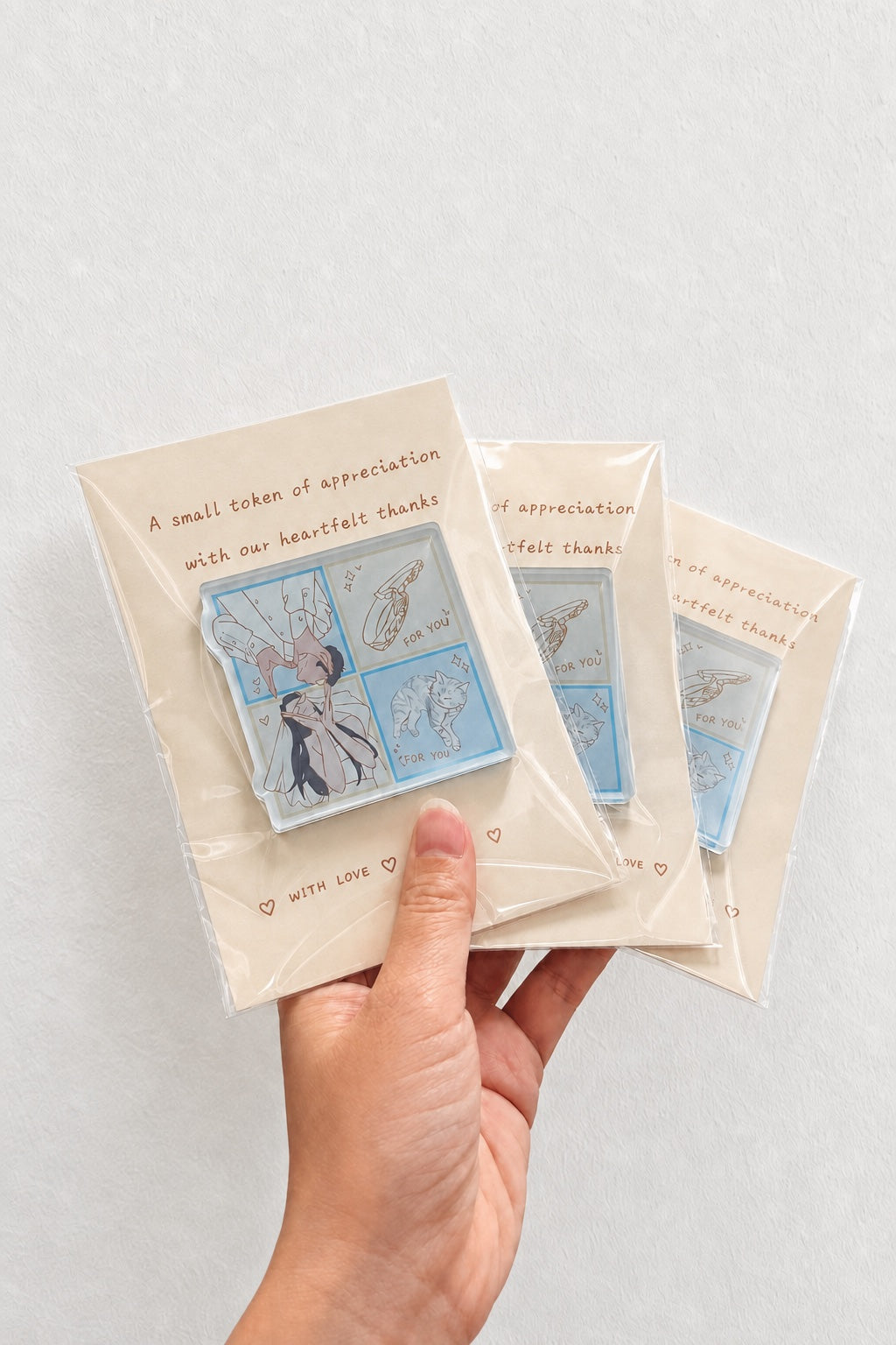 A personalized illustrated acrylic keepsake held by hand